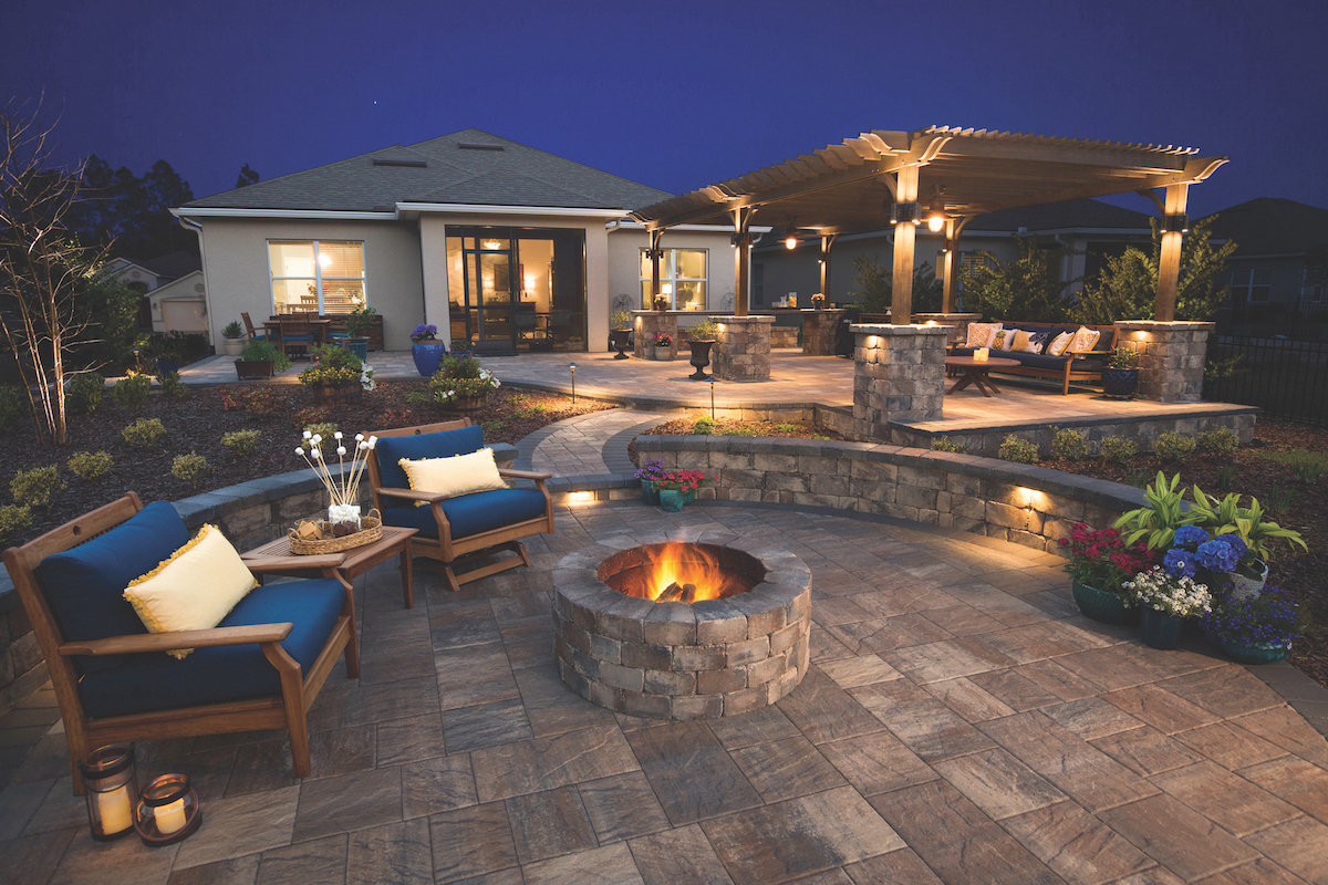 Beautiful paver patio wall and fire pit at night