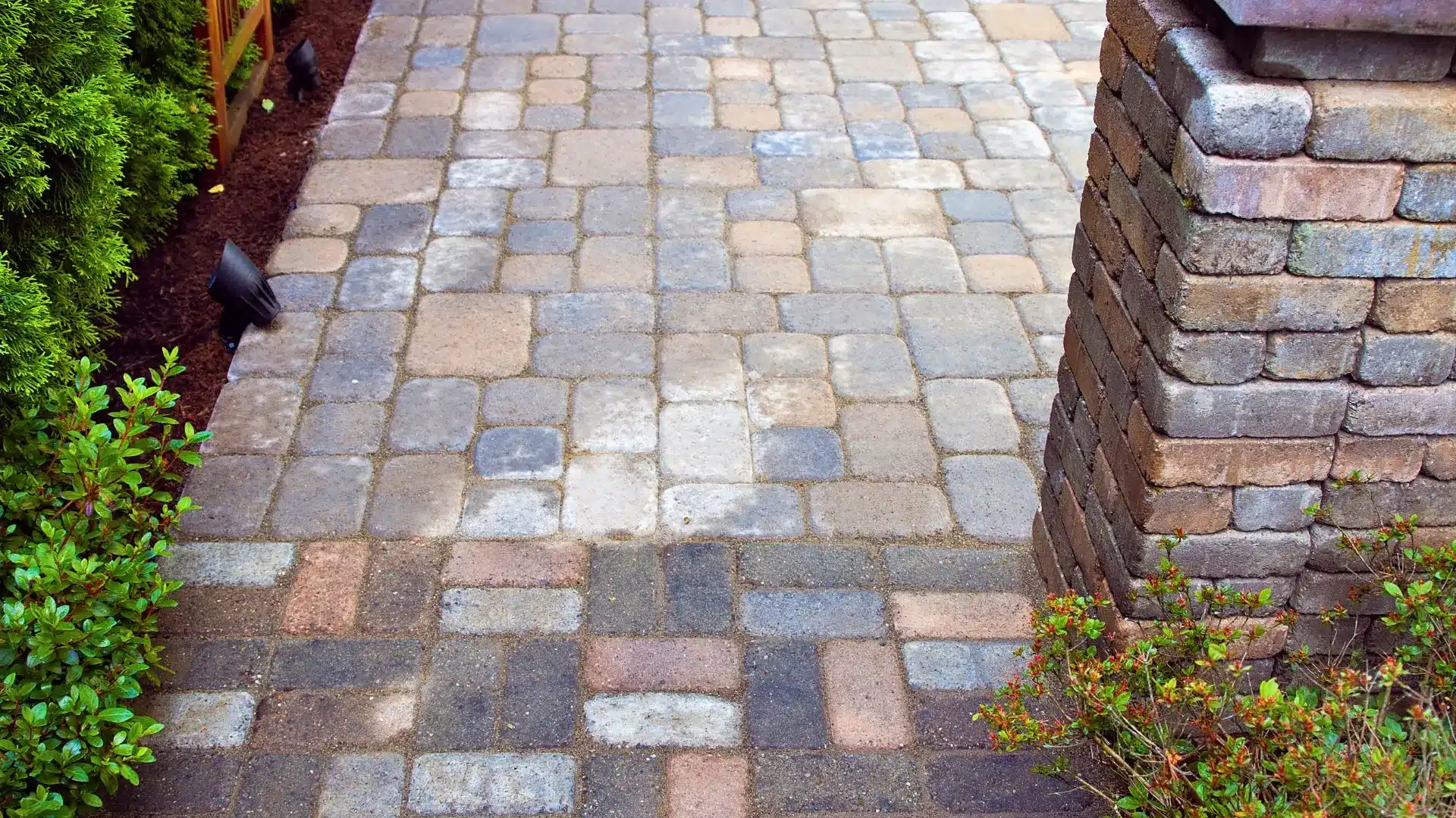 Paver patio and walkway defining distinct areas in a small backyard